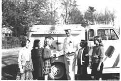 Black-and-white photo of children standing next to a truck with an ice lolly painted on the driver's door
