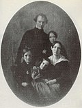 A black-and-white photograph of a mother and father posed with their son and two daughters