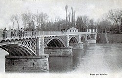 Black and white photograph of a bridge over a river.