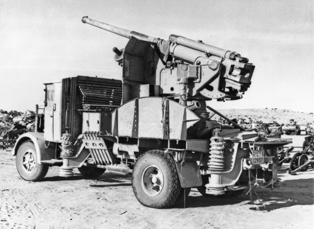 File:An Italian 90-53 gun on a truck mounting joining the rows of derelict Axis vehicles and equipment jettisoned by Rommel's army.jpg