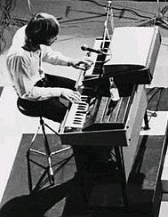 Black and white photo of Ray Manzarek playing a Gibson G-101 and Rhodes Piano Bass