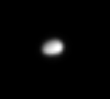 A blurry image of Polydeuces from afar, showing a vaguely ellipsoidal object