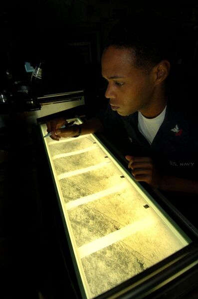 File:US Navy 040924-N-6213R-038 Intelligence Specialist 2nd Class Damon Jenkins of Los Angeles, Calif., reviews aerial reconnaissance imagery on a light table in the Carrier Intelligence Center (CVIC).jpg