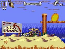 A screenshot of a beach level from the game. Pictured on screen are the playable character Rocko, and his dog Spunky. A deck is elevated above ground level, below which there is water. To the left of the deck is a chair.