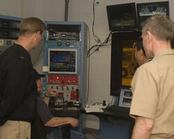 US Navy 091013-N-4288H-006 Engineering Technician Wayne Wood, second from the left, explains instrument readings from a biofuels test on an F404 engine from an F-A-18.jpg