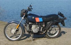 Black BMW R80G/S parked in front of a lake