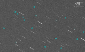 A telescope image showing stars as streaks and Kosmos 1408 debris as circled dots