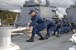 Defense.gov News Photo 100930-N-2855B-251 - U.S. Navy sailors aboard the guided missile destroyer USS Bainbridge DDG 96 haul in a mooring line while mooring the ship in Faslane Scotland on.jpg