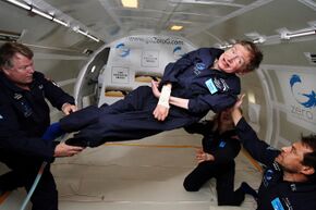 Hawking, without his wheelchair, floating weightless in the air inside a plane