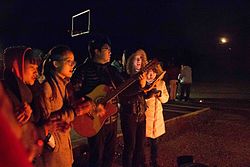 modern photo of Chinese Christians playing guitar and singing by a campfire