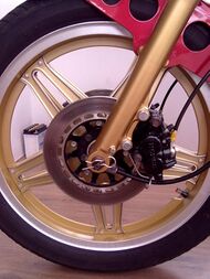 Gold reverse Comstar front wheel from a Honda CB400NC with twin piston brake caliper
