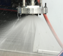 A pintle injector is shown during a cold flow test. Both flow paths are active.