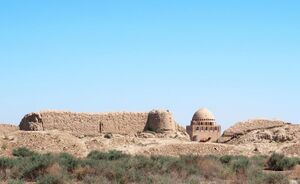 Photograph of the remnants of Merv today including a citadel wall and a domed building