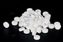 Pile of round aciclovir tablets.jpg