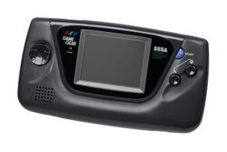 A black Game Gear handheld system. From left to right: the directional controls, the screen, and two buttons labeled "1" and "2".