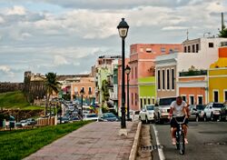 Cars, houses, street light, man on bicycle and El Morro in Old San Juan.jpg
