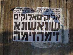 Two identical posters side-by-side on an outdoor wall reading "God hates lechery" in Hebrew