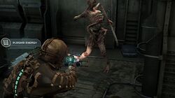 The image shows the player's character, Issac Clarke, pointing his weapon at a deformed humanoid. He has a lit cyan "spine" along the back of his space suit, indicating the player has maximum health points.