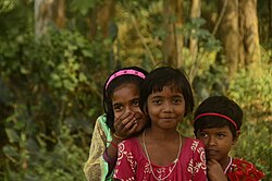Three children reacting to seeing tourists in a remote location in India