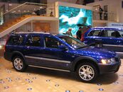 Passenger side view of blue XC70 OR with silver door trim, rocker trim and roof rails