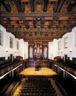 Bridges Hall of Music interior, with elaborate wood paneling and a pipe organ