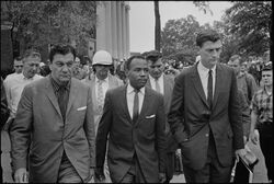 James Meredith accompanied by federal officials on either side before the columns of the Lyceum