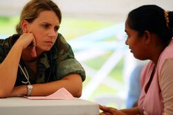 A nurse listens to a young woman