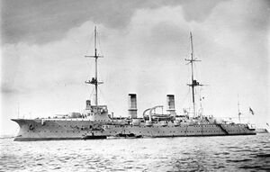 A large warship with several guns and two tall masts at anchor