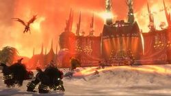 Screenshot showing a giant concert stage dominating the background, accented by gothic elements such as towering spires; the foreground shows several forces converging on the stage, including a flying winged creature, two people mounted on bear-like creatures, a giant brute, and several other ground forces.
