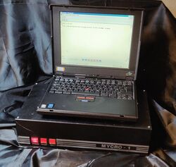 Picture of the Mycro-1 with a portable computer running a terminal emulation software to connect to the Mycro-1
