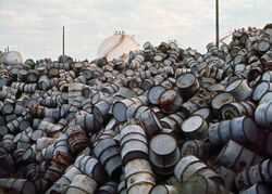 A MOUNTAIN OF DAMAGED OIL DRUMS NEAR THE EXXON REFINERY - NARA - 546000 (cropped).jpg