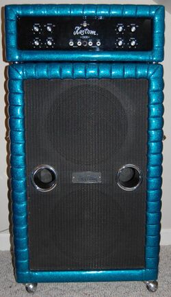 A 1970s era amplifier unit sitting on top of a large bass speaker cabinet. The speaker cabinet contains two fifteen-inch loudspeakers.