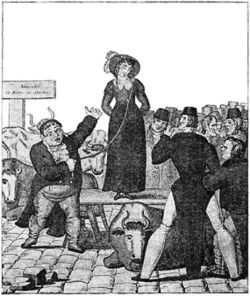 Woman standing on a raised platform surrounded by men.