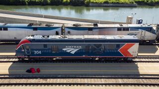 A blue diesel locomotive with red and silver chevrons at the rear