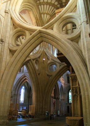 A huge undecorated Gothic arch spans the width of the cathedral nave, with an inverted arch above it, giving scissors-like appearance