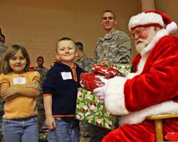 Pvt. Evan Allen Dancer, center, smiles as Santa Claus, right, hands gifts to Destiny Hawley and her brother Justin Hawley of Scipio, Ind., during the 3rd Annual Operation Christmas Blessing event at Muscatatuck 111212-A-QU728-005.jpg