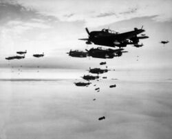 Photograph of a large number of propeller-driven monoplanes dropping bombs