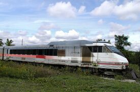 A passenger trainset with a geometric red, white, and black color scheme