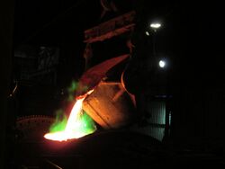 Copper ladle transferring blister copper into furnace for fire refining to produce copper anodes.