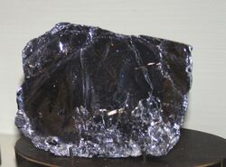 Dark reflective crystal of molybdenite