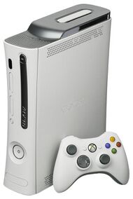 A white Xbox 360 console with a white Xbox 360 controller propped up in front of it.