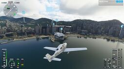 Screenshot of the game, featuring a Cirrus SR22 flying towards Hong Kong's Victoria Harbour. At the edges are the flight parameters, and the Hong Kong Convention Center is pinpointed.