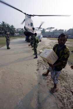 US Navy 071204-M-1226J-016 Bangladeshi Citizens, offload food rations from a Marine CH-46E assigned to Marine Medium Helicopter Squadron (HMM) 166 (REIN), 11th Marine Expeditionary Unit (MEU) Special Operations Capable (SOC).jpg