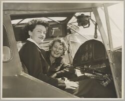 Australian Women Pilots' Association Air Reliability Trial entrants Meg Cornwell (left) and Margaret Sincotts in the cockpit of an Auster J-4 Archer monoplane on the tarmac at an airfield, 1953 (16289750475).jpg