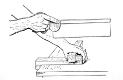 Illustration showing how the workpiece is held against the bench hook.