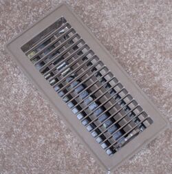 A photo of a floor-mounted register from which heated or cooled air enters a room.