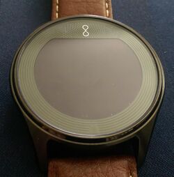 Front side of a black Olio Model One smartwatch with a brown leather strap