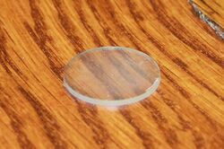 A transparent disc sitting on a wooden table