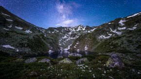 Jazhincë Lake at night, with Milky Way Galaxy background.