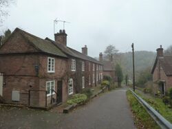 A row of brick terraced cottages (left), a detached house below and to the right